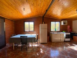 a kitchen with a table and a refrigerator in a room at Hotel Campestre Iparoma in Estancia Campo Aroma