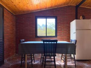 a kitchen with a table and chairs and a refrigerator at Hotel Campestre Iparoma in Estancia Campo Aroma