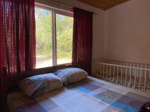 a bedroom with a bed with a window and a crib at Hotel Campestre Iparoma in Estancia Campo Aroma