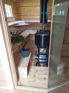 a tiny house with a wood stove in the floor at Wanha Koulu Tahko Onnela, 4mh, Palju, Sauna, Tupakeittiö, Wifi, Liikuntasali, RinteetSpaRavintola 6km, Lemmikit OK, Edukas in Reittiö