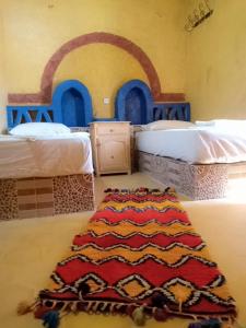 Postel nebo postele na pokoji v ubytování Les Pyramides Hotel Merzouga