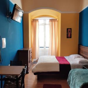 a bedroom with a bed and a window and a table at Wake Up Hostel in La Paz