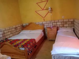 Postel nebo postele na pokoji v ubytování Les Pyramides Hotel Merzouga