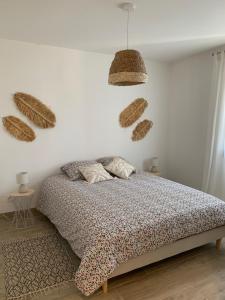a bedroom with a bed and some baskets on the wall at La maison de la vallée in Ranville