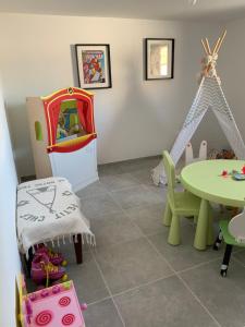 una sala giochi con tavolo e tenda per i giochi di La maison de la vallée a Ranville