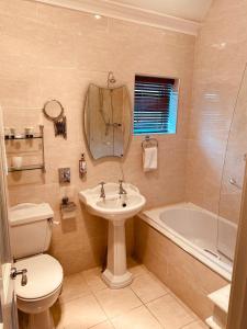 łazienka z umywalką, toaletą i wanną w obiekcie Red Cliff Lodge w mieście Spanish Point