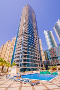 a tall building with a swimming pool in front of it at Full Apartment in Dubai Marina,80m from beach in Dubai