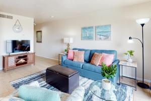 a living room with a blue couch and a table at Mystic Harbor 207 in Padre Island