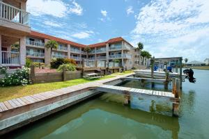 a house with a swimming pool and a boat in the water at Mystic Harbor 207 in Padre Island