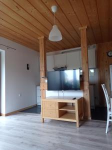 a living room with a large tv and a wooden ceiling at apartamentyDvorskie in Nowy Sącz