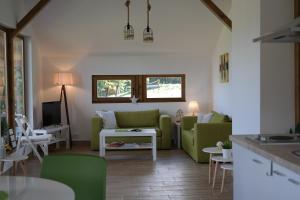 a living room with a green couch and a table at LIPA houses & spa in Sopot