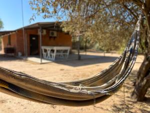 a hammock hanging from a tree in front of a house at Hotel Campestre Iparoma in Estancia Campo Aroma