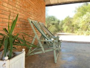 two lawn chairs sitting next to a brick wall at Hotel Campestre Iparoma in Estancia Campo Aroma