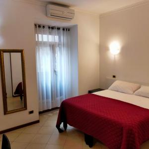 ローマにあるB&B Missiのベッドルーム1室(赤い毛布と鏡付きのベッド1台付)