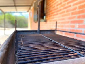 an empty grill in front of a brick building at Hotel Campestre Iparoma in Estancia Campo Aroma