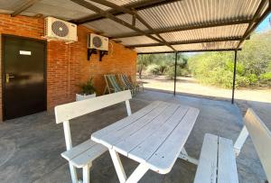 a wooden picnic table and chairs on a patio at Hotel Campestre Iparoma in Estancia Campo Aroma