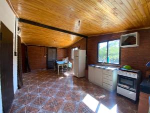 a kitchen with a refrigerator and a table in it at Hotel Campestre Iparoma in Estancia Campo Aroma