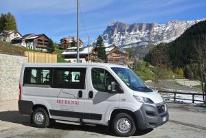 een wit busje geparkeerd voor een berg bij Apartments & Garnì Pre Da Nai in La Villa