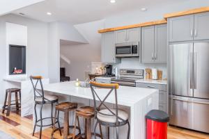 a kitchen with white cabinets and bar stools at Old Lytle Cove Rd - Upper Unit in Swannanoa
