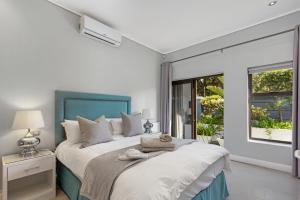 Un dormitorio con una cama grande con cabecero azul. en OCEAN BREEZE SUNSET BEACH - Cape Town, en Ciudad del Cabo 44 fotos más