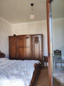 a bedroom with a large wooden bed and a mirror at ILIANNO in Tabakhmela