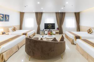 Habitación de hotel con 2 camas y sofá en LINK HOTEL Ha Long en Ha Long