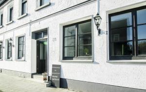 a white building with windows and a sign in front of it at SCHLAFGUT! HOTEL-WILL.ICH Garni in Willich