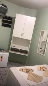 a room with two beds and white cabinets at Pousada Ipojuca in Caruaru