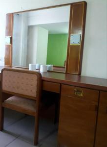 a wooden desk with a large mirror on top of it at MELAKA HOTEL SENTOSA in Melaka