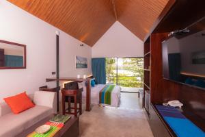 a room with a bed and a couch and a tv at Serendipity Lake - Hikkaduwa in Hikkaduwa