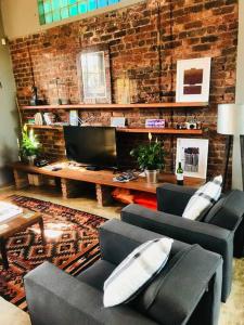 a living room with two couches and a brick wall at (Sub)urban retreat in Johannesburg