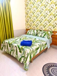 a bed with a blue pillow on it in a room at Sands Inn, Mathiveri in Mathiveri