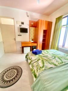 een slaapkamer met een bed en een badkamer met een wastafel bij Sands Inn, Mathiveri in Mathiveri