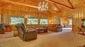 sala de estar amplia con lámpara de araña y sofá en Crystal Creek Chalet, en Welches