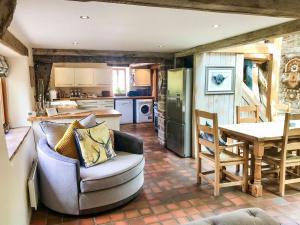 a kitchen and living room with a couch and a table at The Petit Manor in Awre