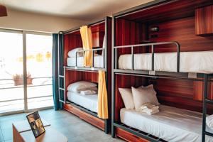 a room with three bunk beds in a room at Selina St Kilda Melbourne in Melbourne