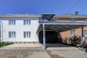 a large white house with a large garage at Ordo Hotel in Karakol