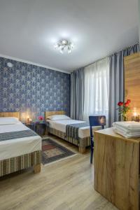 a hotel room with two beds and a table at Ordo Hotel in Karakol