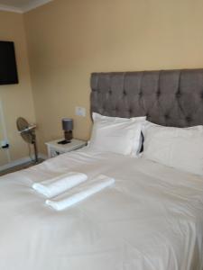 Una cama blanca con una bandeja blanca encima. en On the Wrench en Ciudad del Cabo