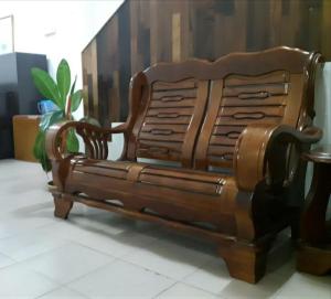 a wooden bench sitting in a room at MELAKA HOTEL SENTOSA in Melaka