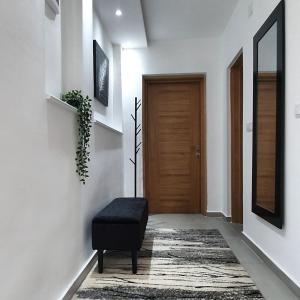 a hallway with a black ottoman in front of a door at Afrodita apartment in Vrdnik