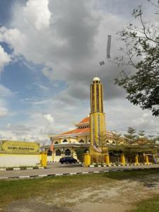 un edificio giallo con una torre dell'orologio davanti di MELAKA HOTEL SENTOSA a Malacca
