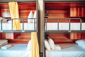 two bunk beds in a room with wooden walls at Roamer St Kilda - formerly Selina St Kilda Melbourne in Melbourne