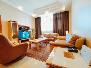 a living room with two couches and a tv at Elite Tower in Seef