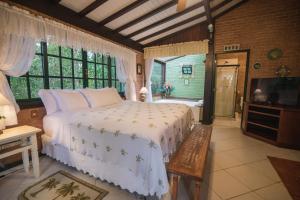 um quarto com uma cama, uma televisão e uma banheira em Urikana Boutique Hotel em Teresópolis