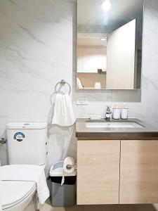 een witte badkamer met een toilet en een wastafel bij Mandani Bay Cebu Near CDU and Parkmall in Mandaue-stad