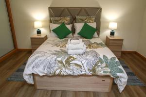 a bedroom with a large bed with green pillows at Torrinha & Sá in Funchal