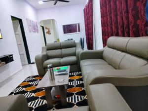 a living room with two couches and a table at MyHomestay07 in Kangar