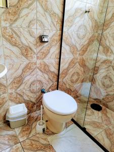 a bathroom with a toilet and a shower at Hospedaria São Benedito in Guararema