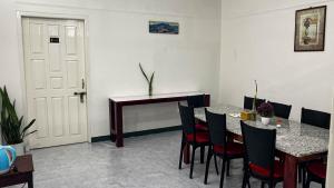 a dining room with a table and chairs and a desk at Abu Homestay in Kohīma +8 photos
